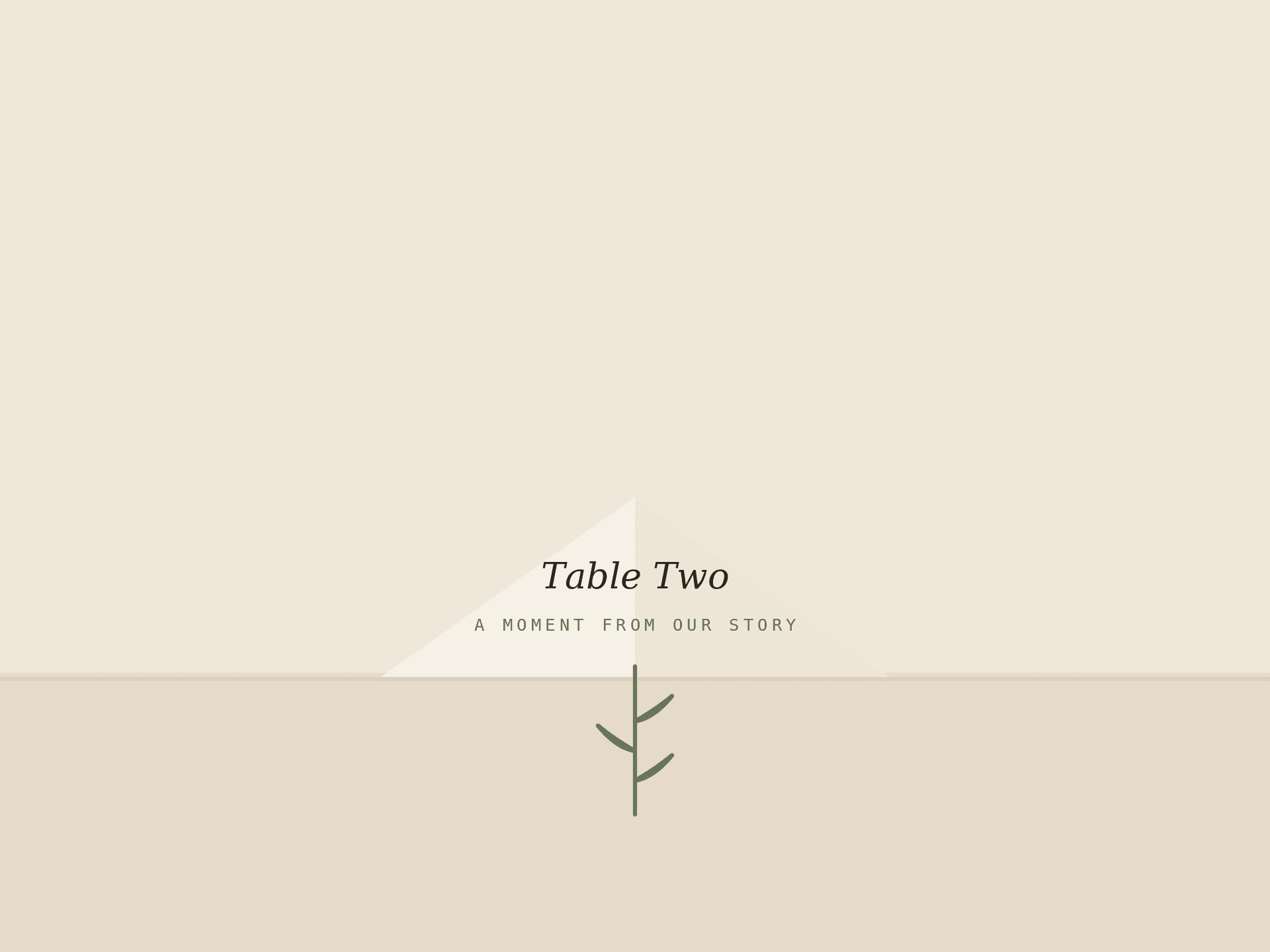 A folded table place card reading Table Two with a short excerpt and a sprig.
